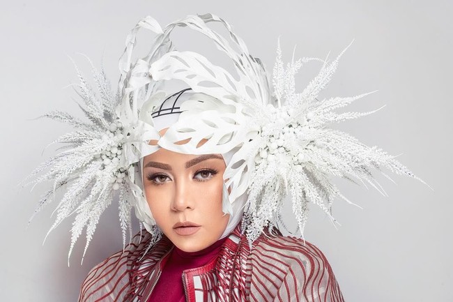 Menjalani pemotretan dengan fotografer Karina Yasmine, Melly Goeslaw tampil spektakuler dengan hijab dan headpiece bunga putih berukuran besar karya Rinaldy Yunardi.Foto: Instagram melly_goeslaw
