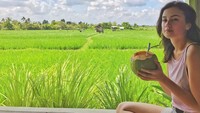 Hayo cantik yang mana? Pemandangan sawah atau wajahnya Kimberly? Gadis berambut panjang ini asyik menikmati es kelapa mudanya. Foto: Instagram @kimberlyryder