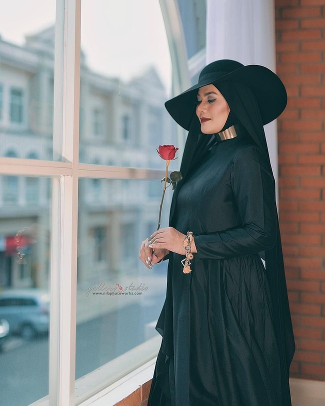 Lagi, gaya Sarita dengan busana serba hitam. Kali ini penampilannya terlihat edgy dengan tambahan topi dan kalung choker. Foto: Instagram/@queen_saritaabdulmukti