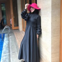 Gaya liburan Sarita Abdul Mukti dengan maxi dress hitam dan topi fuschia. Foto: Instagram/@queen_saritaabdulmukti