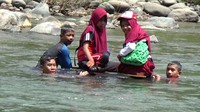Siswa menyeberang sungai dengan menggunakan ban yang ditarik oleh siswa lainnya. Itupun hanya ada satu-satunya ban, sehingga siswa itu harus bolak-balik menjemput.