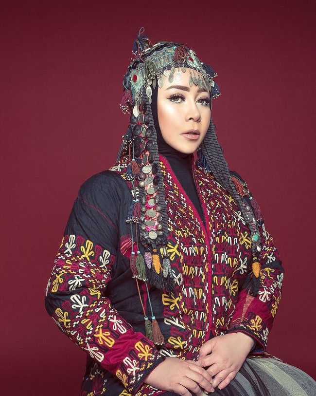 Gaya Melly Goeslaw ini sepertinya terinspirasi kostum tradisional wanita di Mongolia. Melly tampil beda dengan hiasan kepala ala wanita Mongol. Foto: Instagram melly_goeslaw
