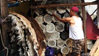 Seorang pedagang merapikan beduk yang akan dijualnya.