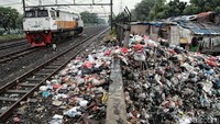 Kereta api melintas di depan tumpukan sampah di kawasan Tanjung Priok.