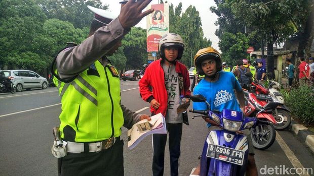 Petugas mengecek kelengkapan surat berkendara berupa SIM dan STNK