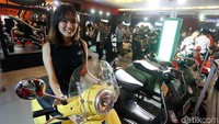 Model berpose di atas Vespa.