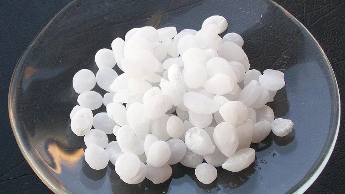 Sodium hidroksida dalam bentuk pelet. Ada pula yang bentuknya cairan.