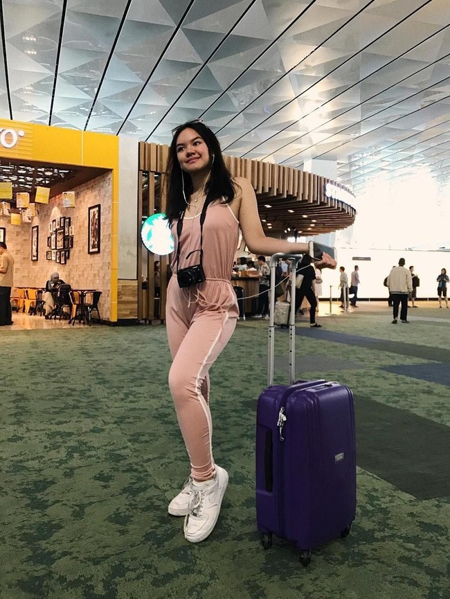 Gaya athleisure Shafa Harris di bandara dengan jumpsuit warna pink pastel. Foto: Instagram/@shafaharris
