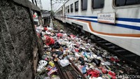 Kereta api Walahar melintas di samping tumpukan sampah.