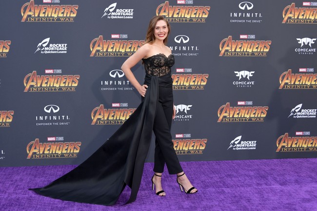 Elizabeth Olsen si pemeran Scarlet Witch tampil memikat dengan jumpsuit hitam rancangan Oscar de la Renta. Bustier berbahan lace serta aksen belt panjang menyapu lantai membuat penampilannya dramatis nan seduktif. Foto: Dok. Getty Images