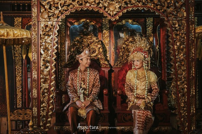 Raditya Dika dan Anissa Aziza berdandan seperti pengantin Palembang, lengkap dengan atribut emas dan pelaminan yang khas. Dok. Aspictura