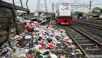 Aneka ragam sampah rumah tangga menumpuk di pinggir rel kereta api.