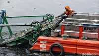 Sampah berupa plastik dan eceng gondok diangkut ke daratan.
