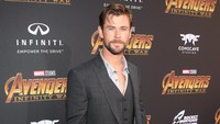 Chris Hemsworth tampil necis dengan setelan jas hitam. Jesse Grant/Getty Images for Disney.
