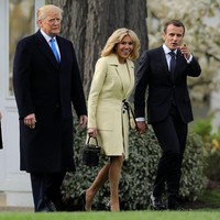 Brigitte Macron di lain sisi, memilih coat dan dress berwarna kuning pucat juga dari Louis Vuitton. Kedua Ibu Negara memilih sepatu pump kulit warna hitam untuk melengkapi penampilannya. Foto: Dok. Getty Images