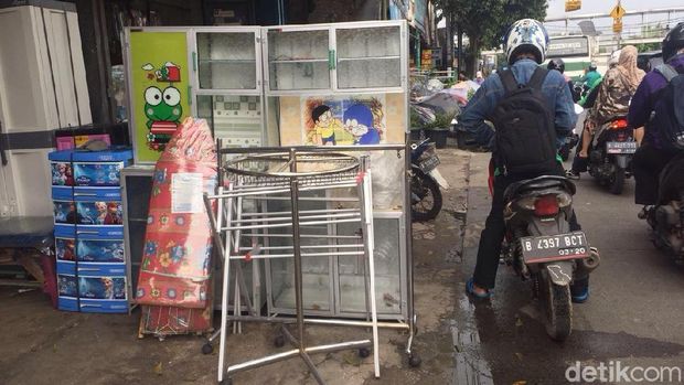 Tak hanya pemotor, para pejalan kaki juga harus berbagi jalan dengan lapak pedagang