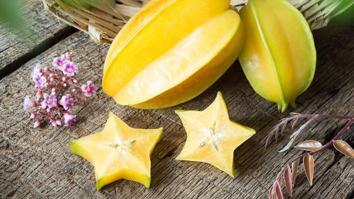 star fruit and piece with its flower and leaf on old wood