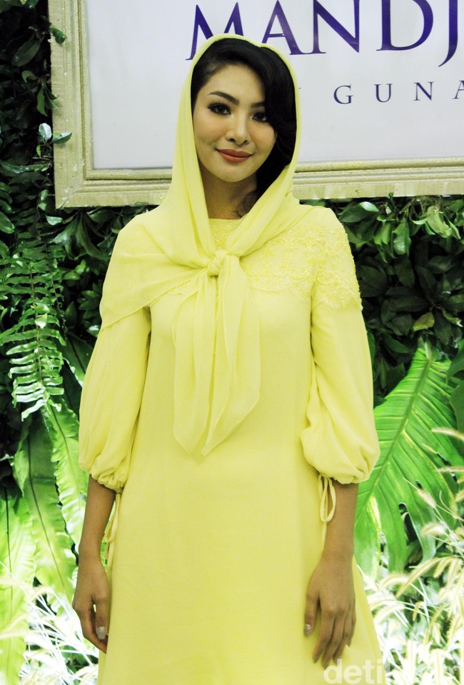 Ia memakai tunik kuning yang dipadukan dengan celana berwarna senada. Tidak ketinggalan kerudung kuning yang membalut kepalanya. Foto: Muhammad Abduh/Wolipop