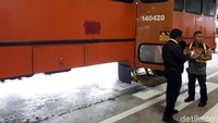 Petugas mengecek penumpang yang akan masuk ke bus.