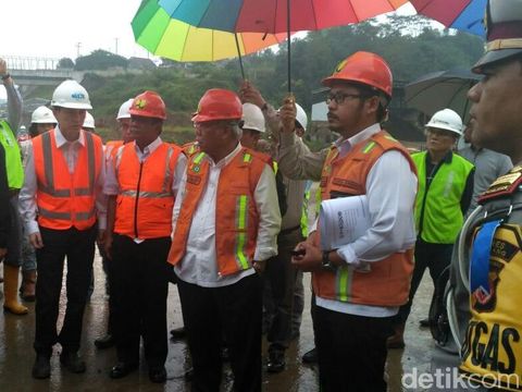 Basuki dipayungi saat meninjau tol Cisumdawu