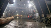 Tak lama, Basuki memasuki lorong terowongan. Sambil berjalan, dia berbincang dengan petugas proyek dan mendengar penjelasan petugas proyek.