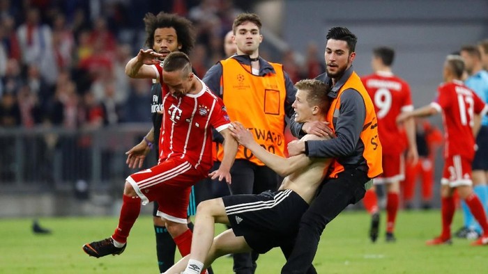 Soccer Football - Champions League Semi Final First Leg - Bayern Munich vs Real Madrid - Allianz Arena, Munich, Germany - April 25, 2018   Bayern Munichs Franck Ribery as a steward tackles a pitch invader after the match   REUTERS/Kai Pfaffenbach