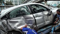 Petugas kepolisian berusaha mengevakuasi mobil Honda HR-V pasca ditabrak Kopaja di Jalan Rasuna Said, Jakarta Selatan, Kamis (26/4).