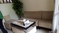  Masuk ke dalam rumah, ada ruang tamu dengan dua sofa berwarna cokelat.