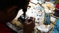 Seorang teknisi tengah menservis HP di Mal ITC Roxy Mas, Jakarta, Kamis (26/4/2018).