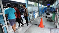 Bus TransJakarta menaikkan penumpang di Halte Simprug.