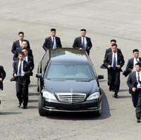 Netizen terpana oleh aksi 12 paspampres yang jogging alias berlari santai menggiring limosin hitam Mercedes-Benz S-Class yang ditumpangi Kim Jong-Un. (Foto: Getty Images)