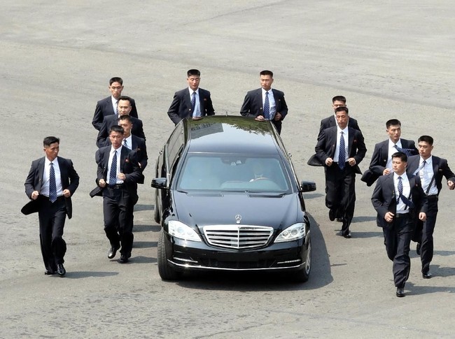 Netizen terpana oleh aksi 12 paspampres yang jogging alias berlari santai menggiring limosin hitam Mercedes-Benz S-Class yang ditumpangi Kim Jong-Un. (Foto: Getty Images)