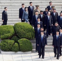 Jabat tangan dan saling balas senyuman antara keduanya sukses mencuri perhatian. Tapi, keberadaan bodyguard atau pasukan pengamanan presiden Kim Jong-Un pun tak luput dari perhatian netizen. (Foto: Reuters)