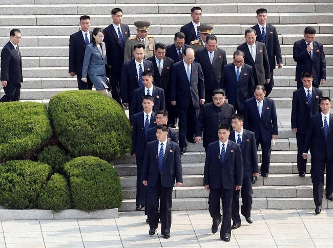 Jabat tangan dan saling balas senyuman antara keduanya sukses mencuri perhatian. Tapi, keberadaan bodyguard atau pasukan pengamanan presiden Kim Jong-Un pun tak luput dari perhatian netizen. (Foto: Reuters)