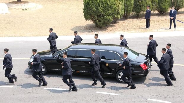 Security personnel run alongside a vehicle carrying North Korean leader Kim Jong Un at the truce village of Panmunjom inside the demilitarized zone separating the two Koreas, South Korea, April 27, 2018.   Korea Summit Press Pool/Pool via Reuters