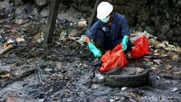 Sisa tumpahan minyak dan sampah dimasukkan ke kantong plastik.