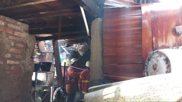 Petugas menyisir titik api di dalam bangunan kontrakan