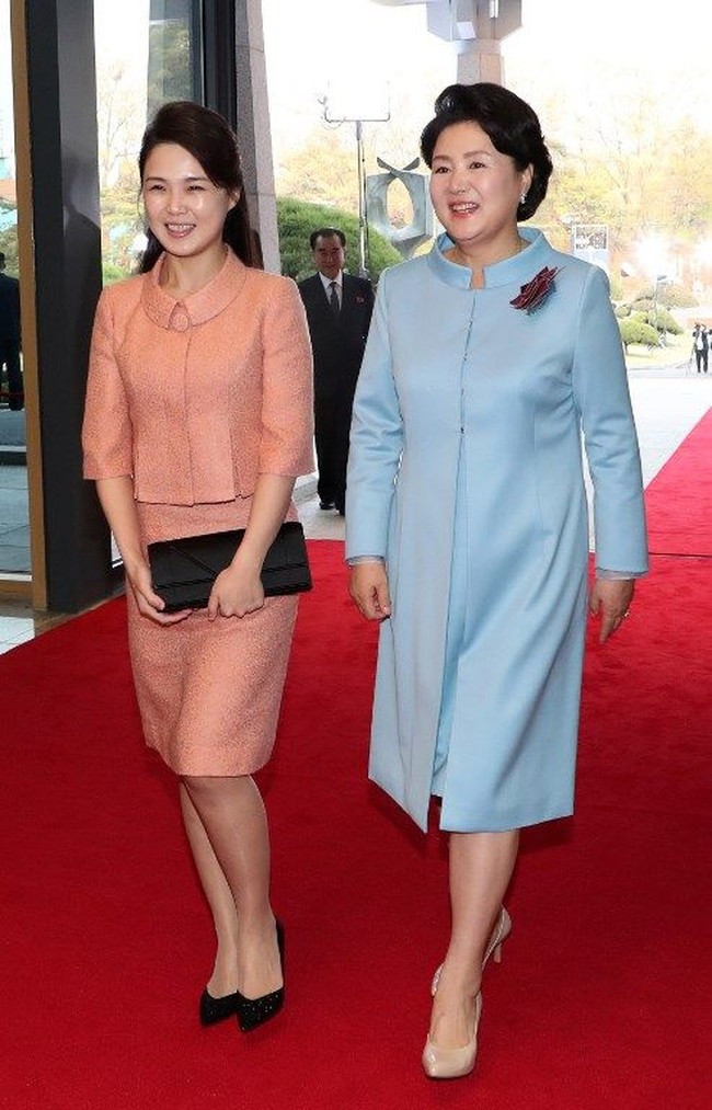Penampilan Ri saat bertemu Ibu Negara Korea Selatan, Kim Jung-sook. Di bulan April 2018 lalu, Ri tampil cantik berbalut setelan warna peach. Ia memilih clutch serta sepatu pump hitam sebagai padanannya. (Foto: AFP)