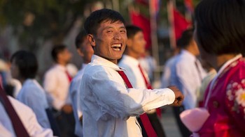 Kumpulan mahasiswa Korea Utara dengan ekspresi bahagia melakukan tarian di taman Pyongyang, Korea Utara. (Foto: Eric Lafforgue)