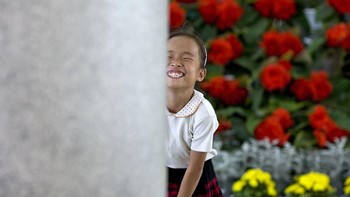 Tawa ceria gadis kecil saat festival International Kimilsungia & Kimjongilia di Pyongyang, Kore Utara. Untuk deretan foto ini ia menemukan sisi lain warga Korea Utara yang masih memiliki senyuman di wajahnya. (Foto: Eric Lafforgue)