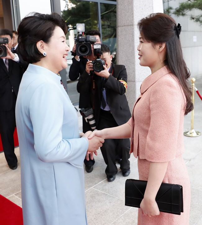 Ri Sol-Ju memilih two-piece dress berwarna peach. Atasannya dipercantik dengan kerah bundar berhiaskan satu kancing sebagai aksen. Foto: Dok. Getty Images