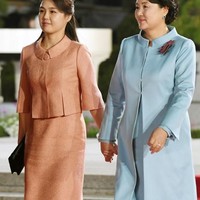 Sementara itu, Kim Jung-sook memilih dress lurus bersiluet coat biru pastel, juga dengan kerah yang membundar. Foto: Reuters