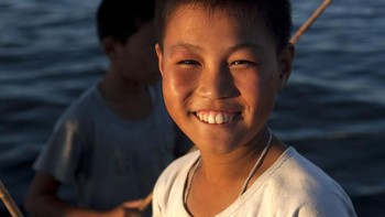 Senyum bocah kecil saat memancing. (Foto: Eric Lafforgue)