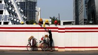 Pekerja proyek pembangunan jalur kereta ringan (LRT) Cawang-Dukuh Atas membeli minuman dari pedagang keliling disela-sela pekerjannya di kawasan Rasuna Said, Jakarta, Rabu (13/9). Pemerintah berharap prioritas pada pembangunan infrastruktur akan mendorong pertumbuhan ekonomi. Dok. APFI.