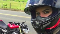 Dia juga berswafoto dengan latar moge Triumph berkelir merah. Foto: Instagram/carollclarke