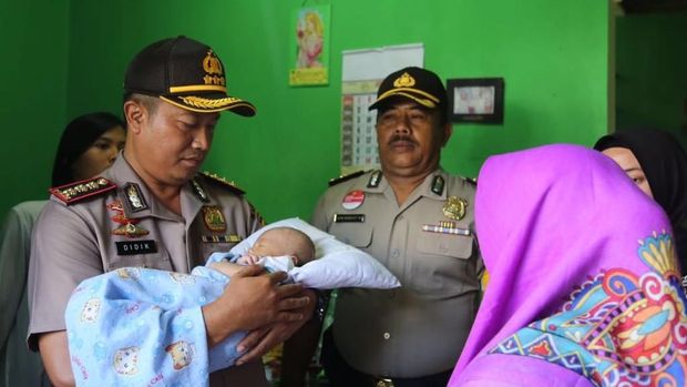 Polisi saat mengambil bayi Aditya dari tangan Jumiyati