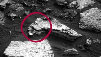 Rover Curiosity milik NASA berhasil menangkap gambar sebuah batu yang penampakkannya sangat mirip dengan wajah manusia saat hendak ciuman. (Foto: CNET)