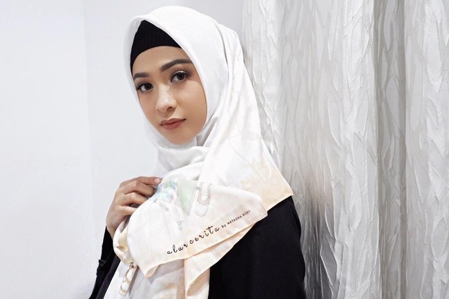 Poppy Bunga tampil cantik mengenakan hijab motif besutan Natasha Rizky bernama Alur Cerita. Bahan voile pada hijab ini juga pilihan tepat untuk ibu hamil karena lembut dan nyaman dipakai. Foto: Instagram/PoppyBungaRiphat
