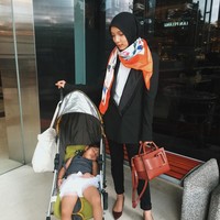 Sematkan scarf motif di leher sebagai syal untuk tampil stylish seketika. Jenahara memadukan scarf satin dengan blazer set bernuansa hitam. Foto: Instagram/JenaharaNasution