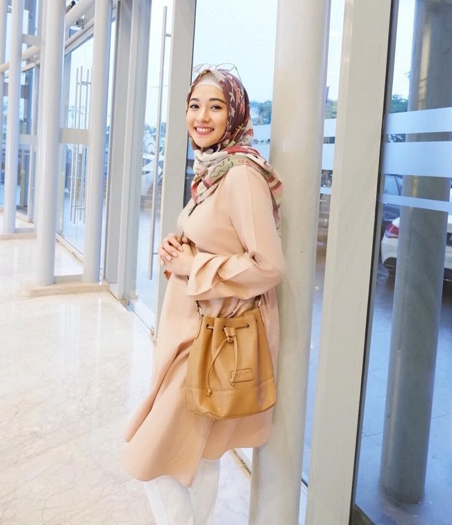 Selain dress, pilihan baju hamil ala Poppy Bunga adalah tunik loose berbahan ringan. Ia sering tampil dengan warna-warna lembut yang menonjolkan sisi femininnya. Foto: Instagram/PoppyBungaRiphat